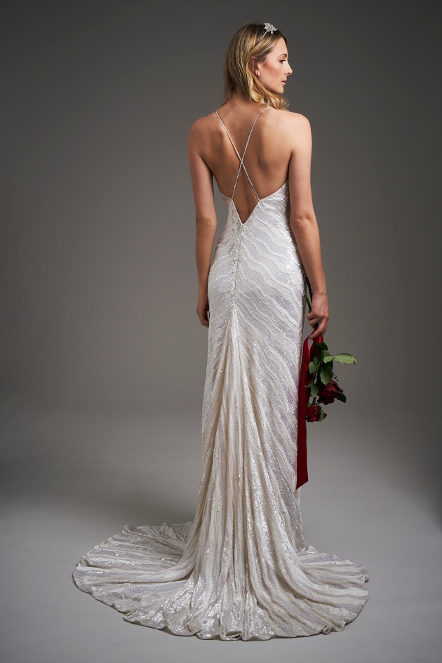 back shot of model wearing a wedding dress holding flowers