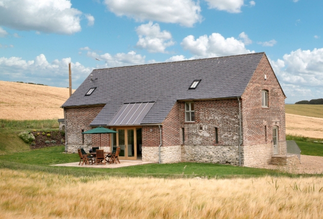 Shot of the barn with a patio surrounded by fields