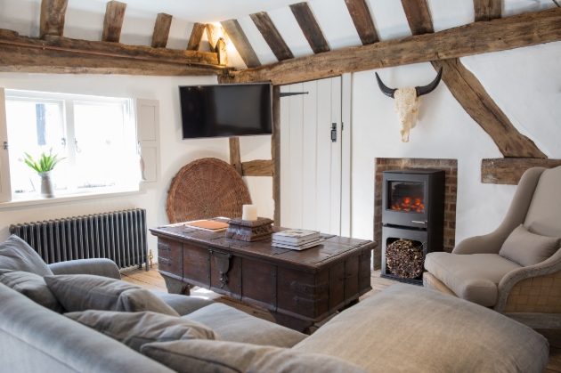 inside cottage, sofas, beams, tv, fire