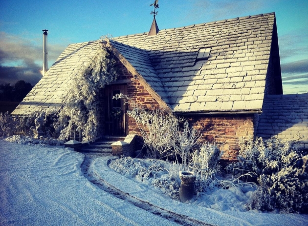 one level cottage covered in snow blue sky