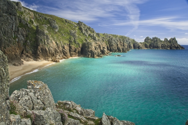 sandy cover with ragged rocks and sea