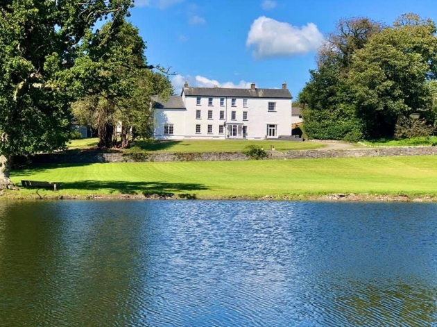 Plas Pantyderi Manor across the lake