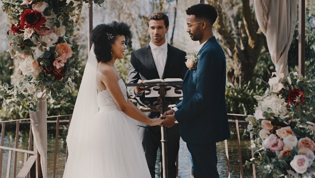 couple standing in front of a man performing a wedding cremony