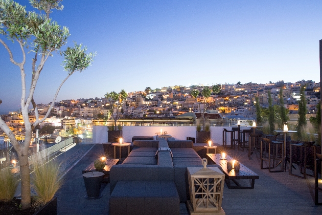 sofas on a terraced at night with the hillside town views in the bakground