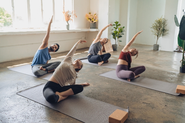 a group in a yoga class sitting on mats