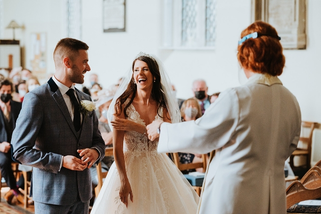 Bride laughing at the altar