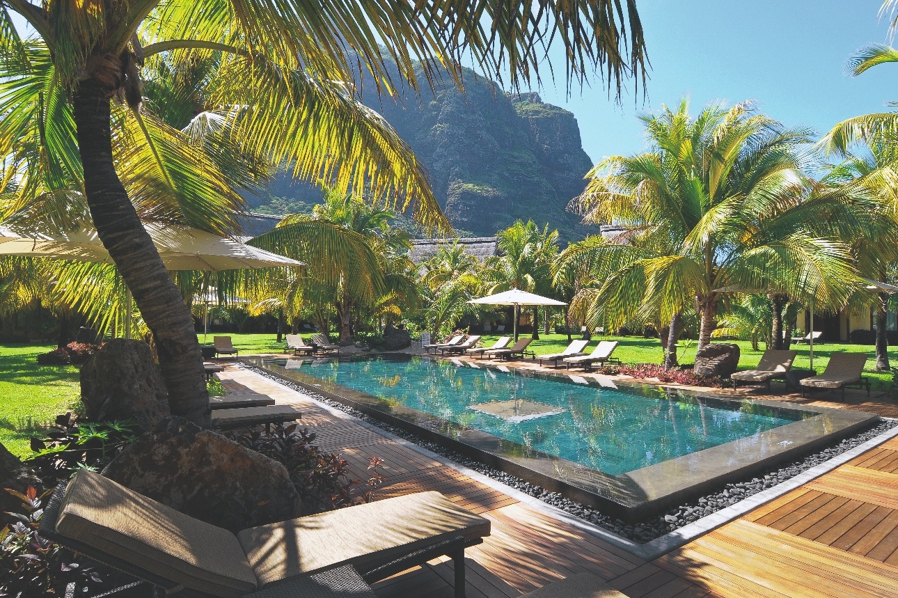 swimming pool and loungers shaded by palm trees