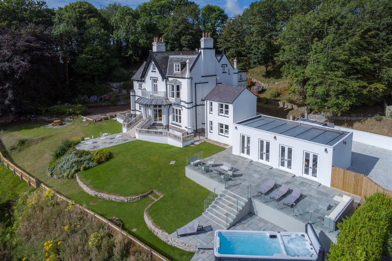large white manor house bird's eye view with private pool and private estate with trees