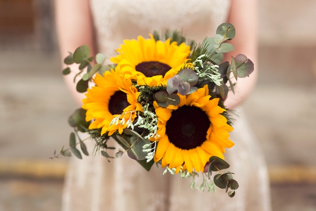 bride holding bouquet of sunflowers