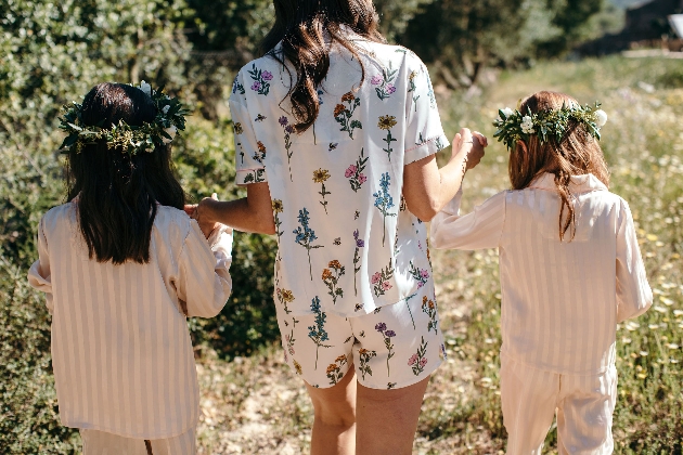 woman holding twp children's hands wearing stripey peach pjs