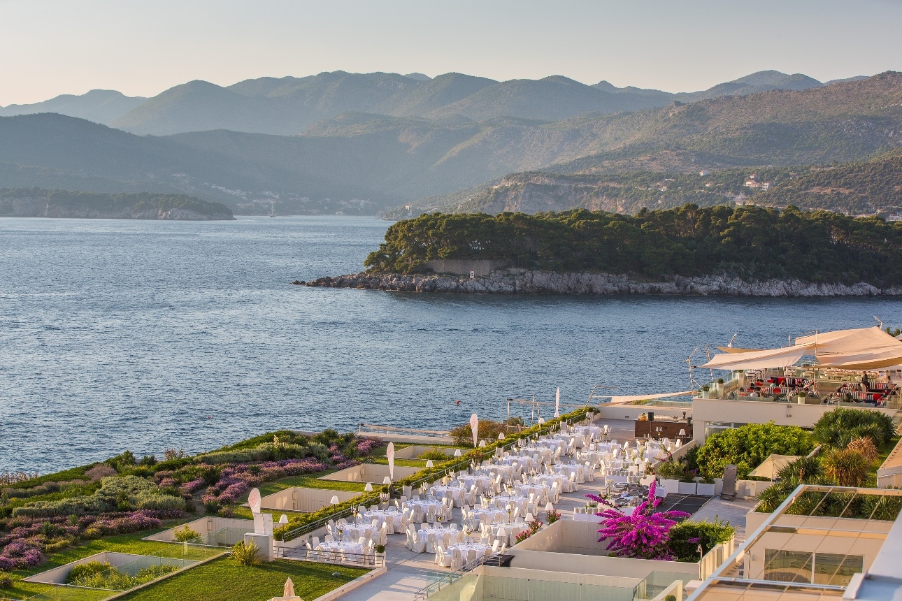 hotel on cliff edge with see views and mountain in background