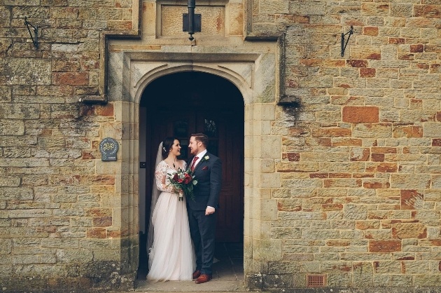 Bride and groom posing in the grounds of Bryngarw House