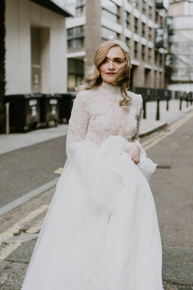 model in nude bodice with lace overlay, sleeved top with high neck and hair piece