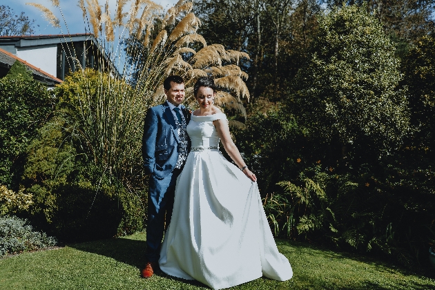 Bride and groom embracing next to a tree