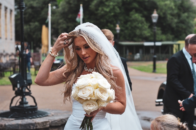 Bride holding a bouquet and walking towards the camera