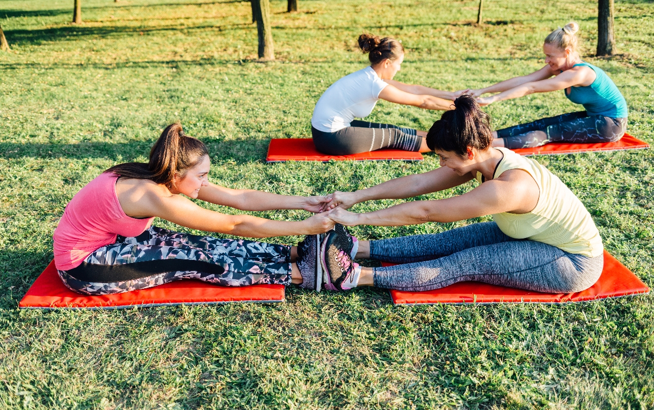 people in pairs exercising outdoors