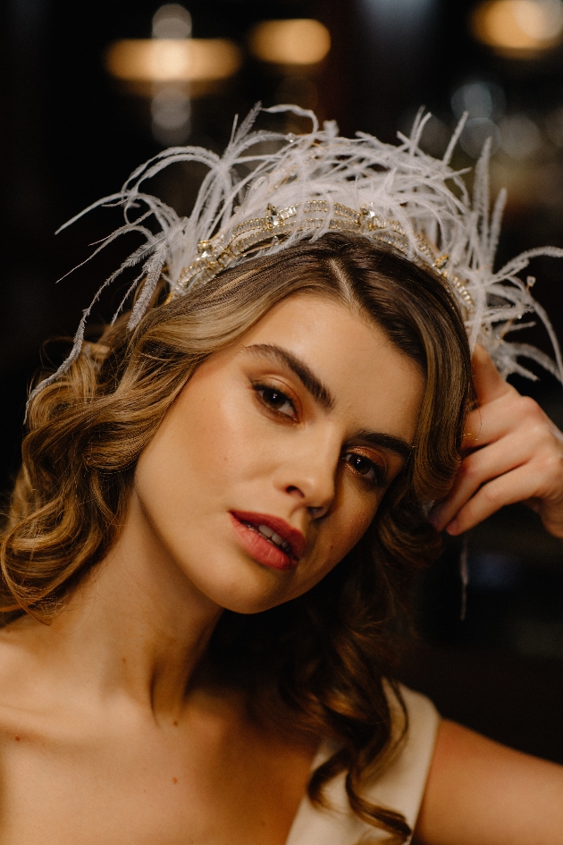 Bride posing wearing a feather headband