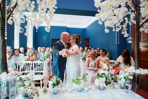 Bride and groom kissing at the end of the alter