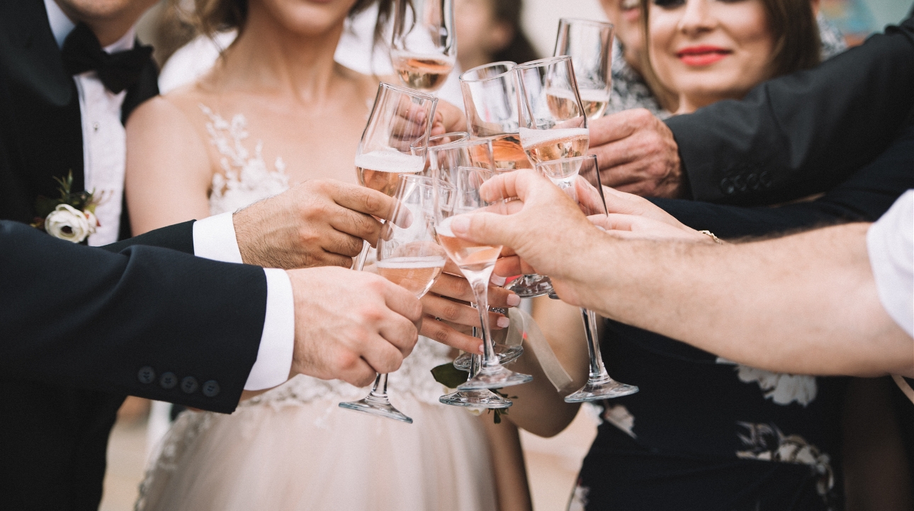 wedding group having a toast and clinking glasses