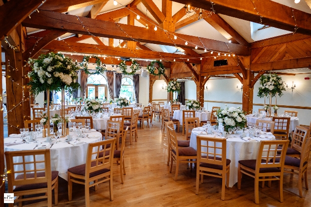 Round tables set up in a wooden barn