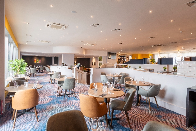 A bright dining room with several small tables