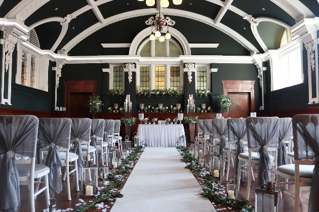 A black and white room decorated with chairs flanking either side of an aisle