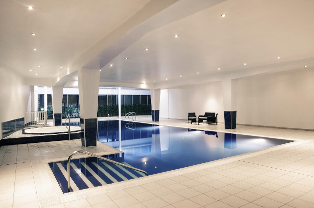 An indoor swimming pool in a large white room