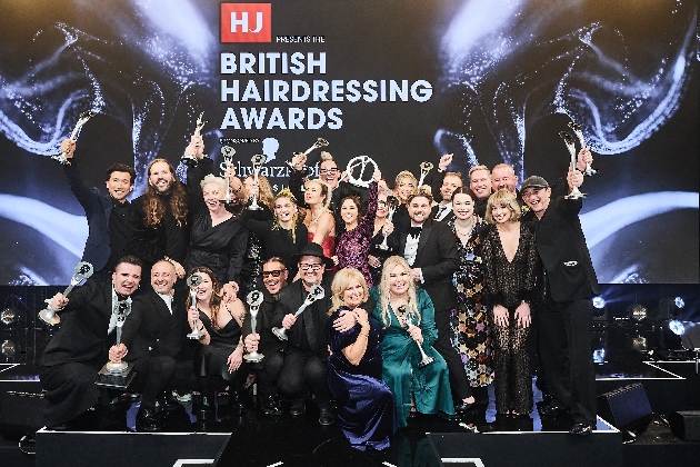 A group of people posing underneath a sign that reads British Hairdressing Awards