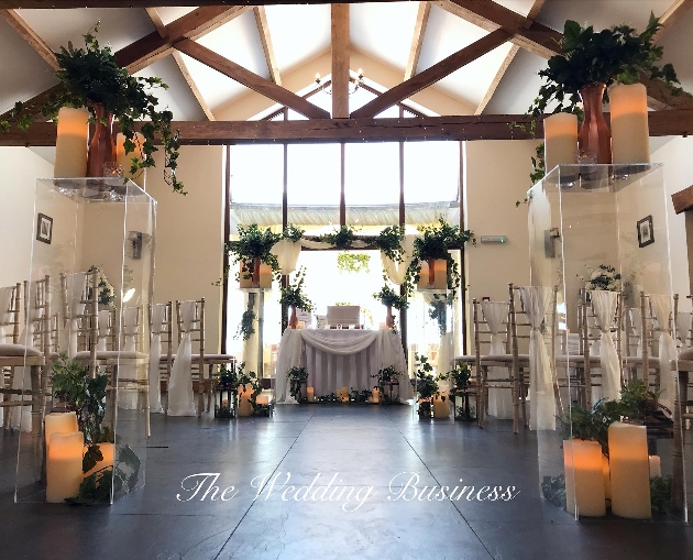 A large groom with a large window and oak beams decorated for a wedding ceremony