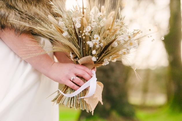 A woman holding a dried wedding bouquet