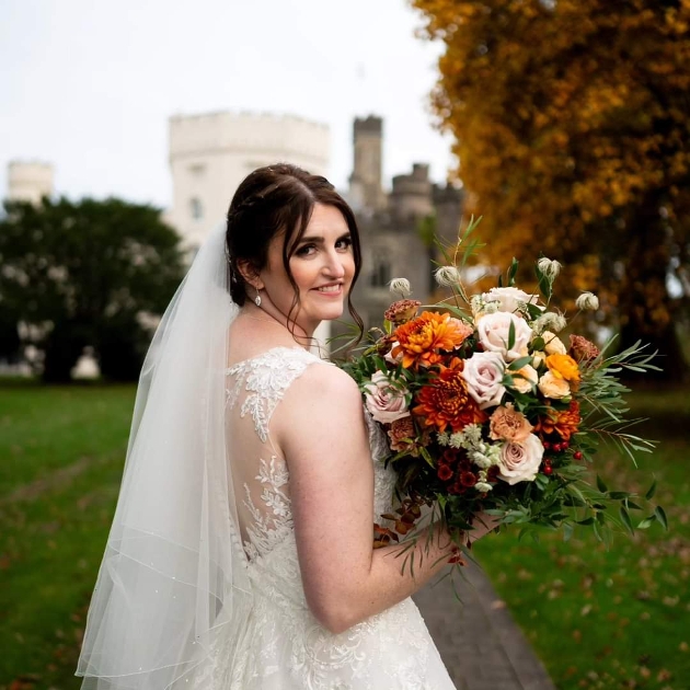 A bride looking at the camera while holding a large bouquet