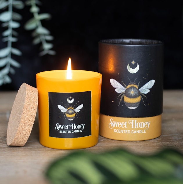 A yellow candle with a sweet honey label on it