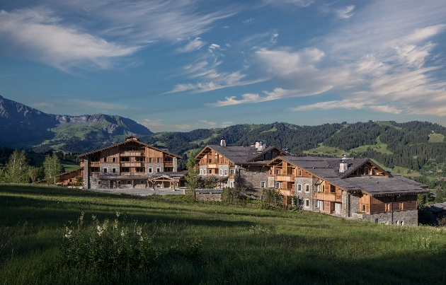 Three wooden buildings sitting in the middle of the mountains