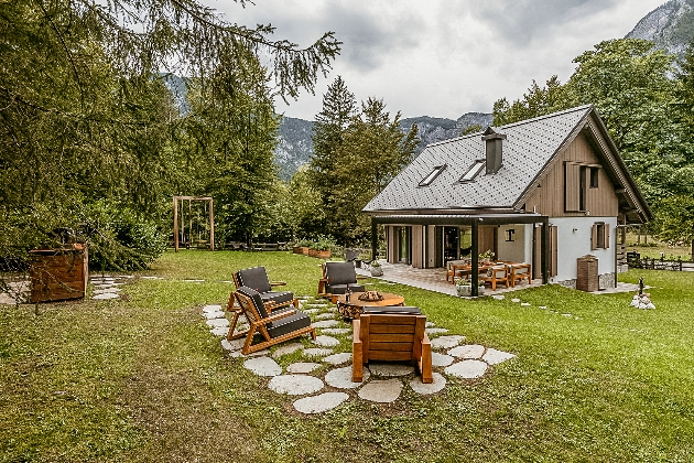 A cabin in the middle of the mountains with outdoor furniture