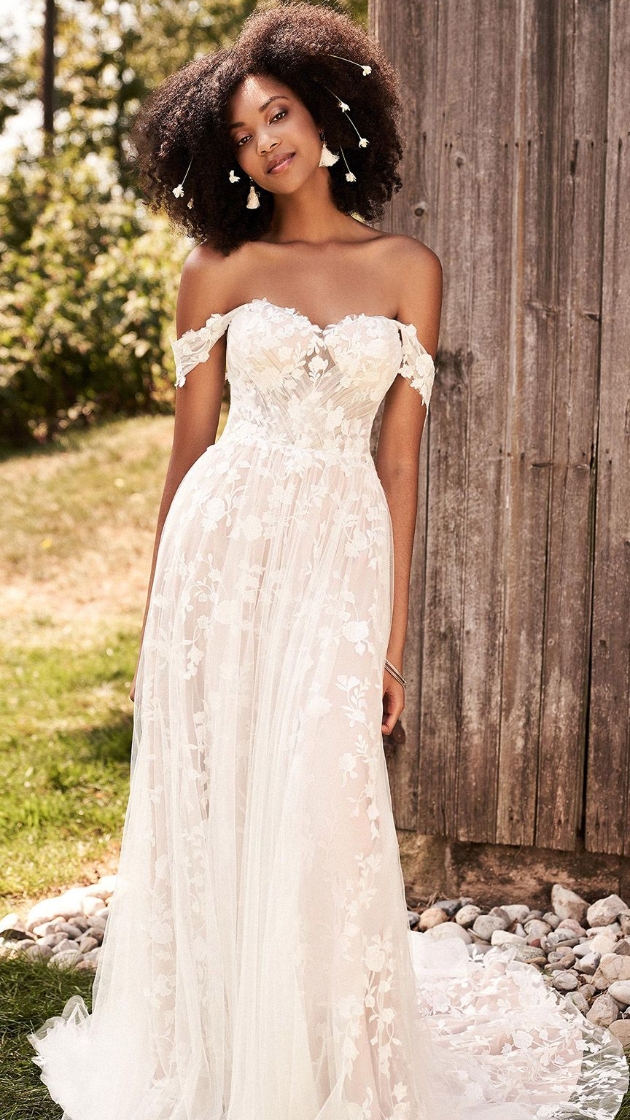 woman in wedding dress next to barn 