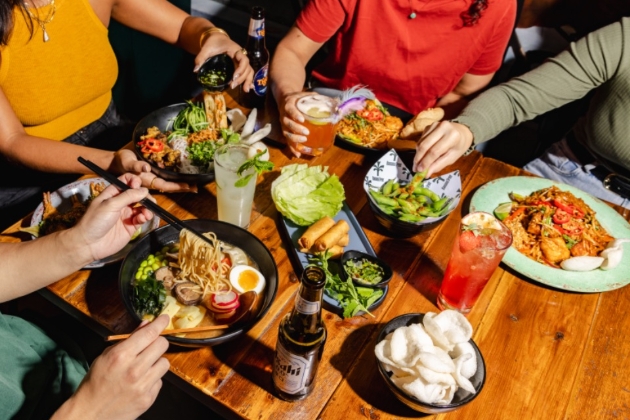 group of people sat round eating a meal