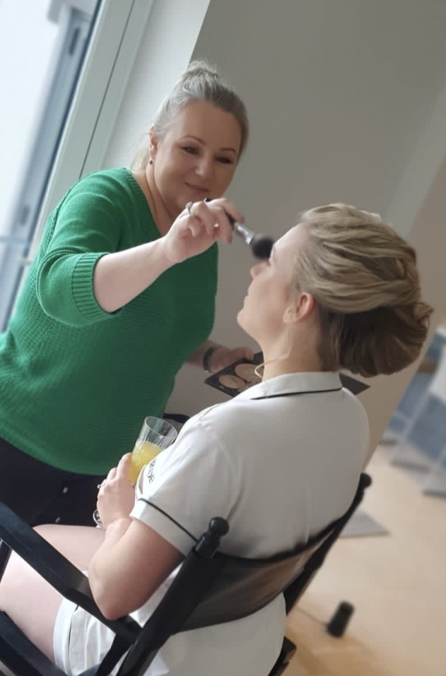 a woman doing another woman's make-up