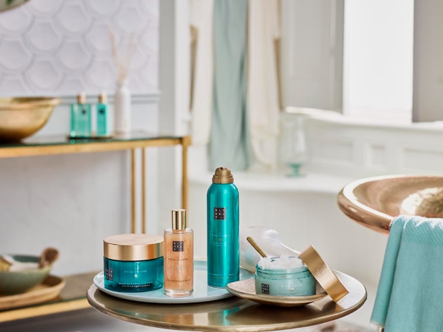 Collection of bath products on side table next to large gold bath
