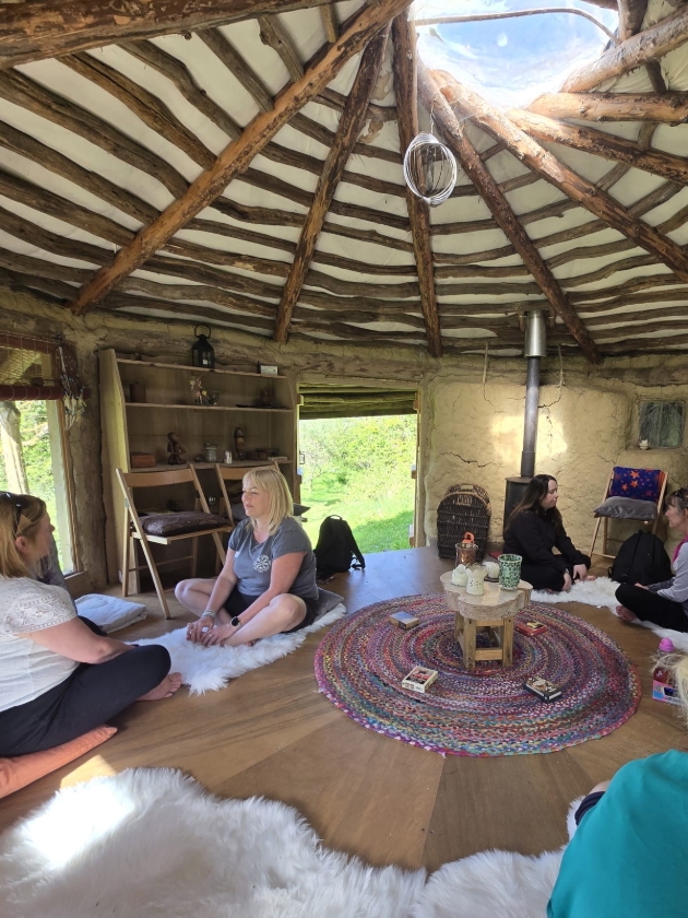 women sat in hut facing each other