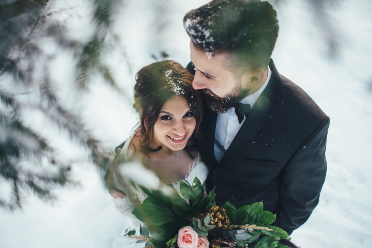 groom and bride in snow on wedding day