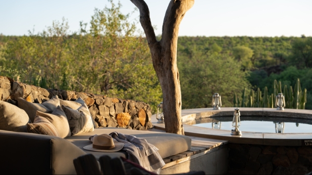 hot tub with views next to outdoor sofa