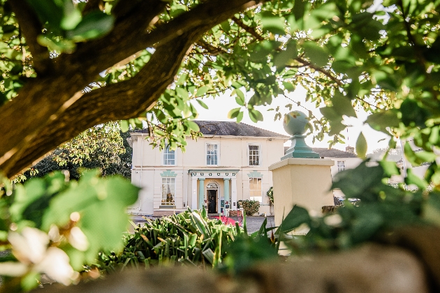 The exterior of.a country house surrounded by trees