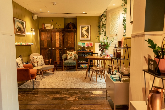 A cosy, living room with sofa, tables and chairs