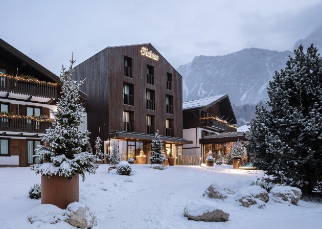 The exterior of a large wooden hotel surrounded by snow