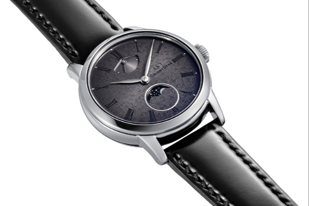 A black watch with a silver frame and dark grey/black face