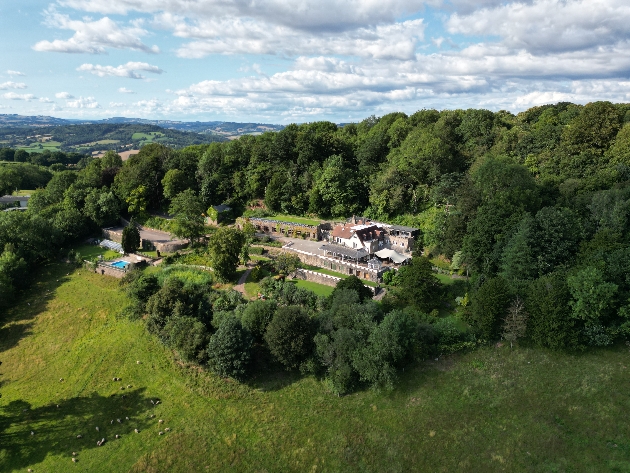 Sky view of a large building surrounded by trees