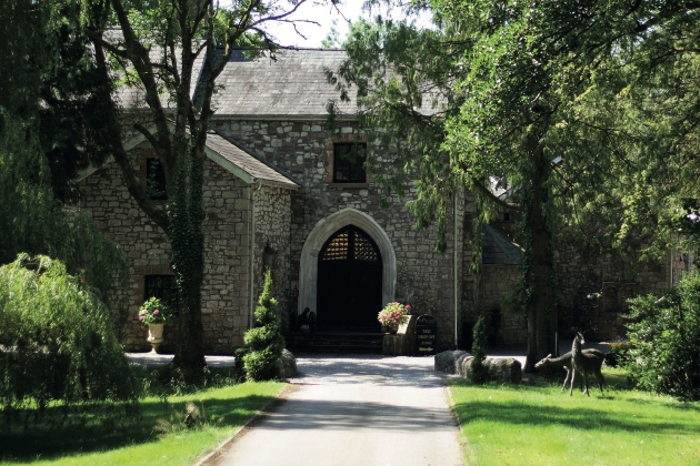 The exterior of a brick building surrounded by trees