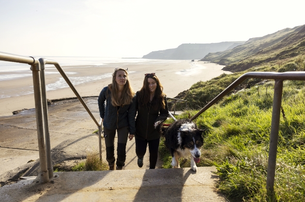 Two women walking a dog