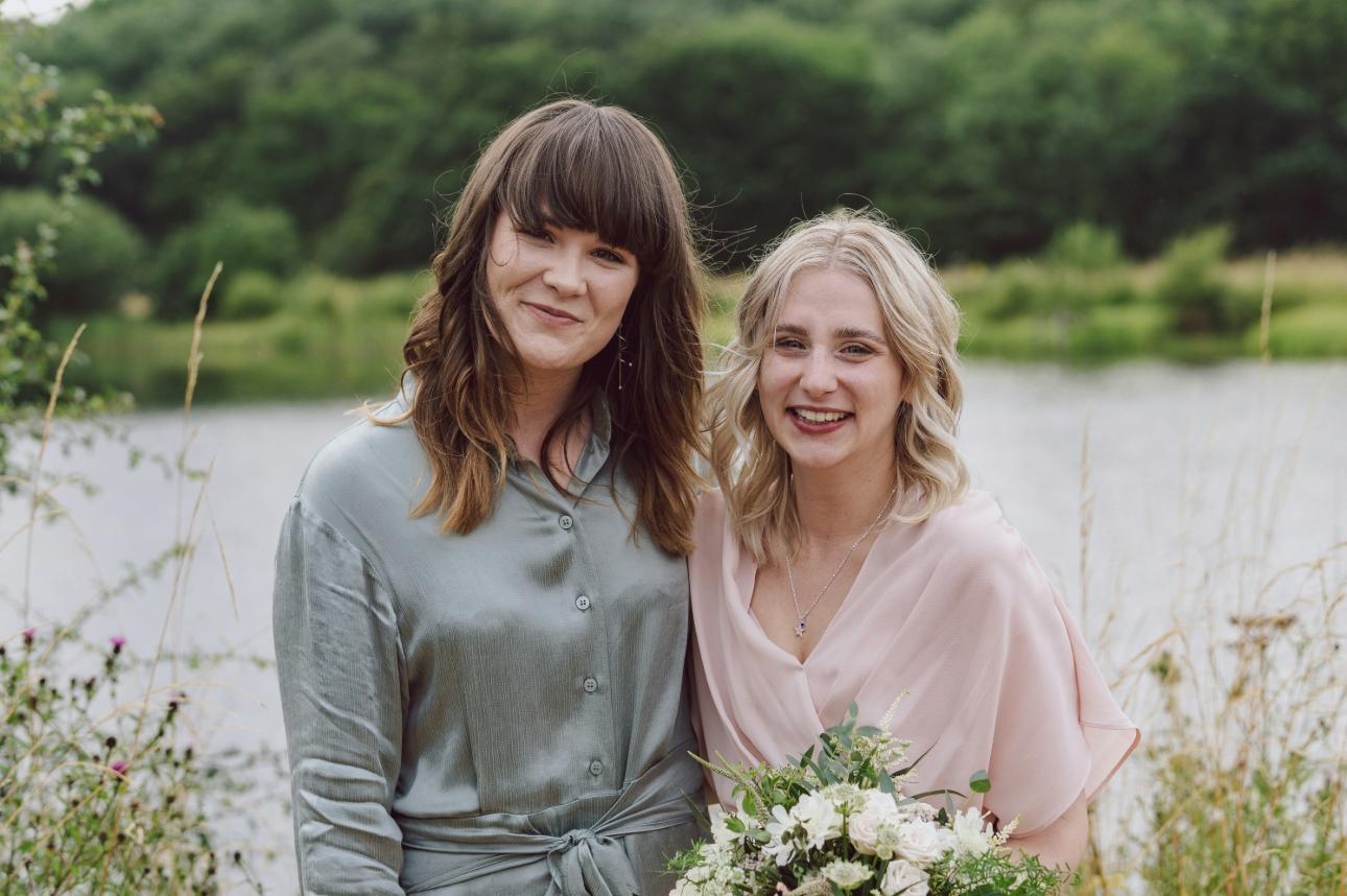 Wedding guest in a blue dress and bridesmaid in a pink dress