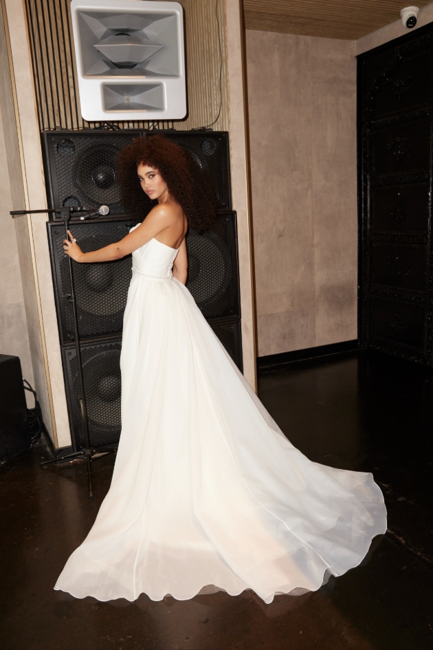Sleek and effortlessly modern, our Kristen gown features a softly draped strapless bodice that contours the figure before flowing into a fluid skirt with a striking thigh-high slit. T